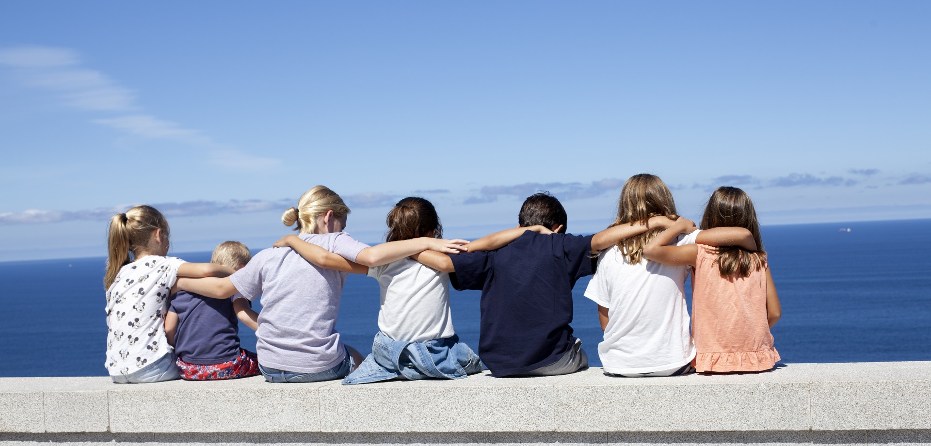 Kinder die sich sitzend im Arm halten